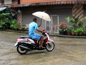 Man_On_a_Scooter_In_Rain_Holding_Umbrella_2-300x225.jpg