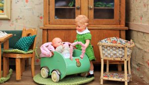 brown-haired-girl-doll-holding-baby-in-bassinet-doll-157596-300x172.jpg